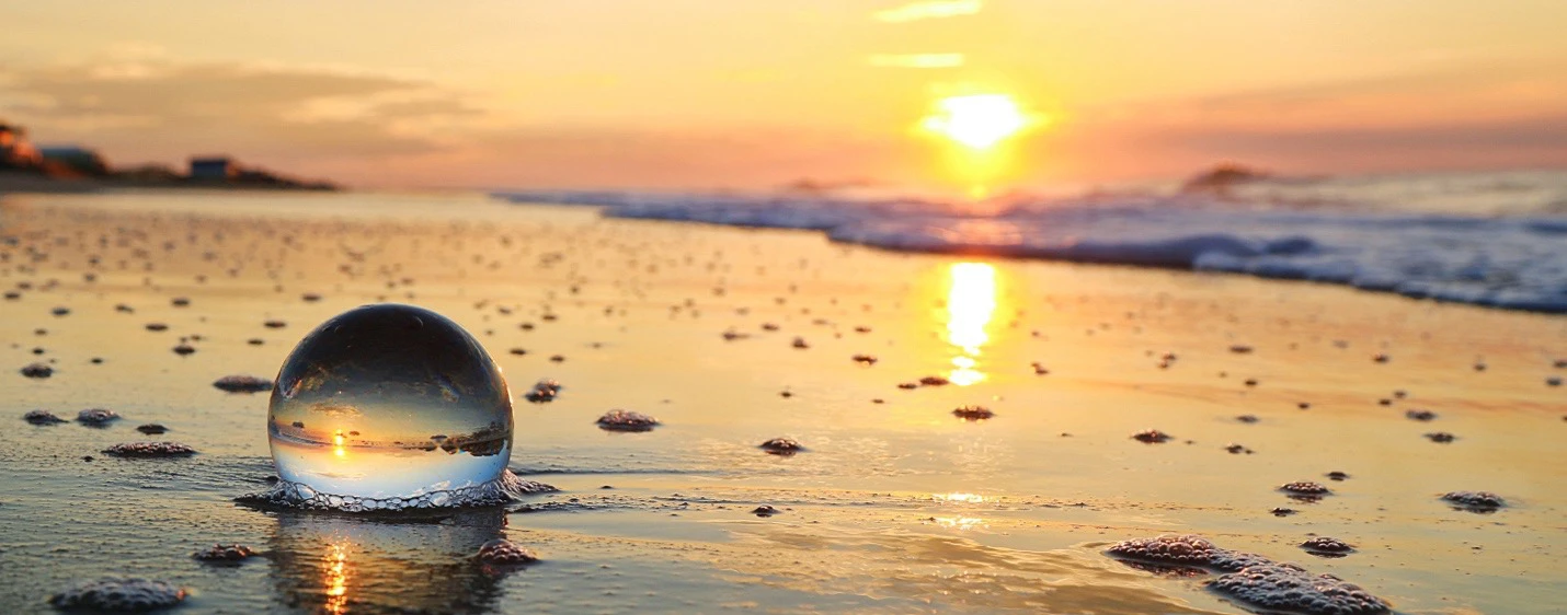 A ball on a beach at sunset.